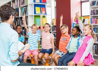 Kids Raising Their Hands In Library At School