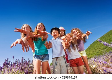 Kids Reaching Out Their Hands To Camera Outdoors