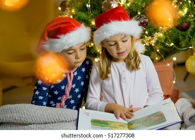 Kids Reading Book By Christmas Tree