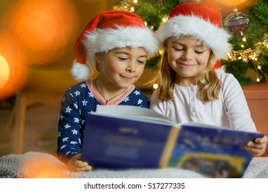 Kids Reading Book By Christmas Tree