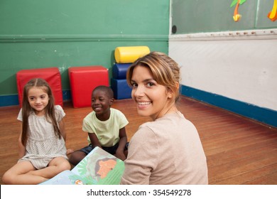 Kids Reading A Book In A Kindergarten Class