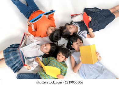 Kids Reading Book Laying On The White Floor ,head To Head, In A Circle Group, Preschool Library,Kindergarten School Education Concept