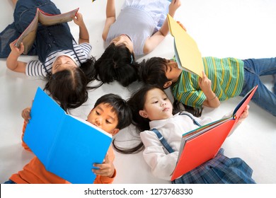 Kids Reading Book Laying On The White Floor ,head To Head, In A Circle Group, Preschool Library,Kindergarten School Education Concept