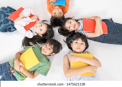 Kids Reading Book Laying On The White Floor ,head To Head, In A Circle Group, Preschool Library,Kindergarten School Education Concept