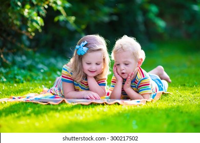 Kids Reading A Book In Summer Garden. Children Study. Boy And Girl Play In School Yard. Preschool Friends Playing And Learning. Siblings Doing Homework. Kindergarten Kid And Toddler Read Books.