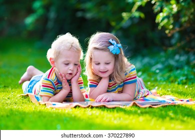 Kids Reading A Book In Summer Garden. Children Study. Boy And Girl Play In School Yard. Preschool Friends Playing And Learning. Siblings Doing Homework. Kindergarten Kid And Toddler Read Books.