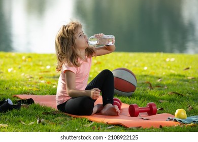 Kids Relax On Sport Mat After Sport Exercises Drink Water Outdoor In Park.