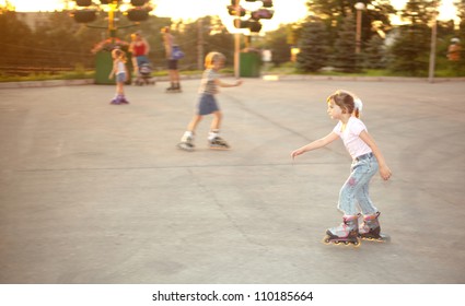 Kids ride on roller skates on skate yard