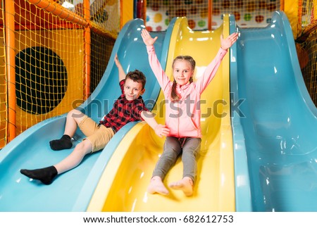 Kids riding from childrens slides in game center