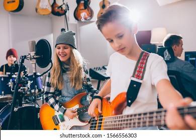 Kids Rock Band Playing Instruments In Music Studio