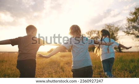 kids run in the park at sunset. happy family children camp kid dream concept. group of children run on the grass at sunset the rays of the sun silhouette. childhood dream fun teamwork concept