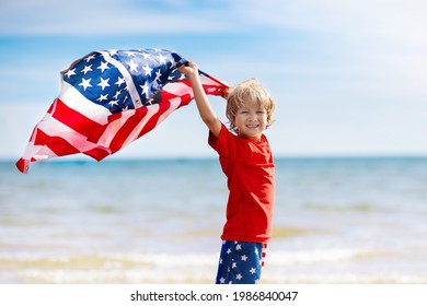 Kids Run With USA Flag On Sunny Beach. 4th Of July Celebration. American Family Fun On Independence Day Weekend. Patriotic Children Celebrate US Holiday. Boy And Girl With Symbols Of America.