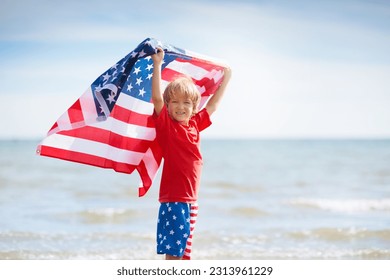 Kids run with USA flag on sunny beach. 4th of July celebration. American family fun on Independence Day weekend. Patriotic children celebrate US holiday. Boy and girl with symbols of America. - Powered by Shutterstock