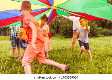 Kids Running In Circle Under Colorful Parachute