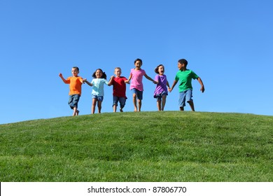 Kids running on grass hill with blue sky