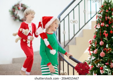 Kids Running Stairs On Christmas Morning. Children In Pajamas Run Downstairs Eager To Open Xmas Presents. Celebration At Home. Winter Family Holiday. Boy And Girl Opening Gifts.