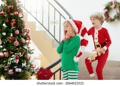 Kids Running Stairs On Christmas Morning. Children In Pajamas Run Downstairs Eager To Open Xmas Presents. Celebration At Home. Winter Family Holiday. Boy And Girl Opening Gifts.