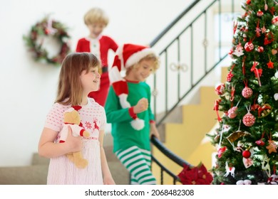 Kids Running Stairs On Christmas Morning. Children In Pajamas Run Downstairs Eager To Open Xmas Presents. Celebration At Home. Winter Family Holiday. Boy And Girl Opening Gifts.