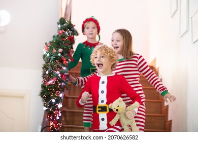 Kids Running Stairs On Christmas Morning. Children In Pajamas Run Downstairs Eager To Open Xmas Presents. Celebration At Home. Winter Family Holiday. Boy And Girl Opening Gifts.