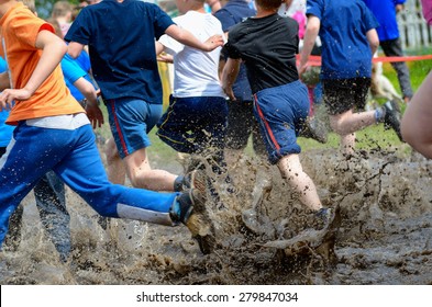 Kids Running Trail Race, Legs In Mud And Water 