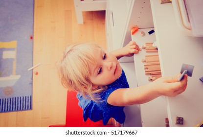 Kids Safety Concept- Little Girl Climbing On Chair To Get Toy