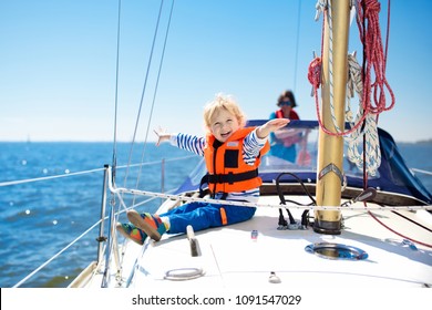 Kids sail on yacht in sea. Child sailing on boat. Little boy in safe life jacket travel on ocean ship. Children enjoy yachting cruise. Summer vacation for family. Young sailor on sailboat front deck.