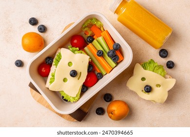 Kids school lunch box with funny fox sandwich with cheese, and fresh vegetables, carrot, tomatoes, celery, blueberries and apricots, orange juice. Back to school background. Top view. - Powered by Shutterstock