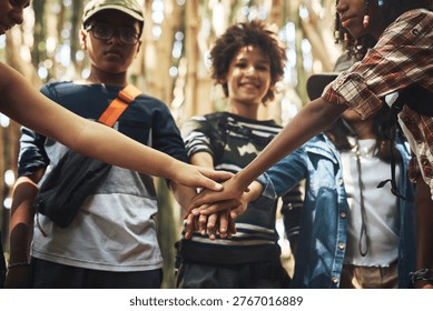Kids, scout and hand stack in forest for support, teamwork and motivation in nature. Portrait, children or huddle with unity gesture for collaboration, solidarity and celebration of wilderness skills