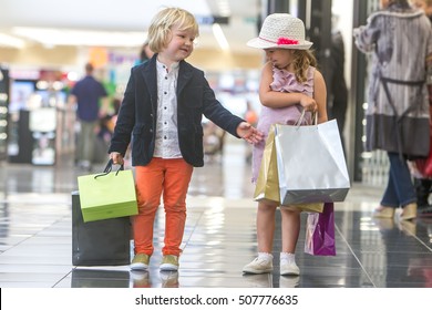 Kids Shopping. Cute Little Girl And Boy On Shopping. Portrait Of Kids With Shopping Bags.