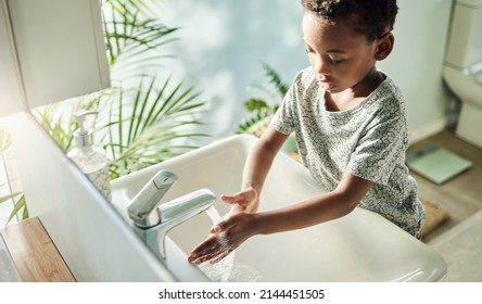 Kids Should Wash Their Hands Often With Soap And Water. High Angle Shot Of A Boy Washing His Hands At A Tap In A Bathroom At Home.