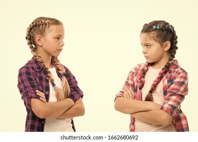 Kids sisters looks strictly. Girls folded arms on chest looks serious white background. Stubborn temper. Stubborn concept. Stubborn kids. Disagreement and stubbornness. Girls offended friends.
