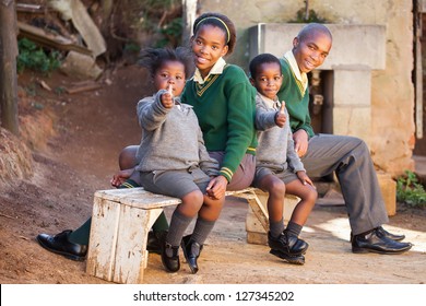 Kids sitting on a bench waiting for the school bus.