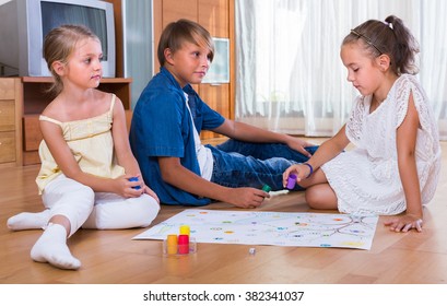 Kids Sitting On Floor At Home With Board Game And Dice 
