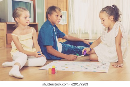 Kids Sitting On Floor At Home With Board Game And Dice 
