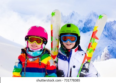 Kids Skiing In Mountains. Active Children With Safety Helmet, Goggles And Poles. Ski Race For Young Kids. Winter Sport For Family. Child Ski Lesson In Alpine School. Little Skier Racing In Snow