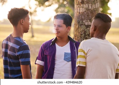 Kids Smoking Cigarette In Park. Concept Of Health Problems And Social Issues Between Young People