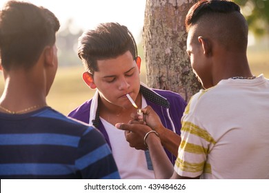 Kids Smoking Cigarette In Park. Concept Of Health Problems And Social Issues Between Young People