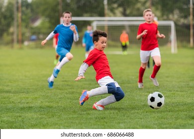 Kids soccer football - young children players match on soccer field 