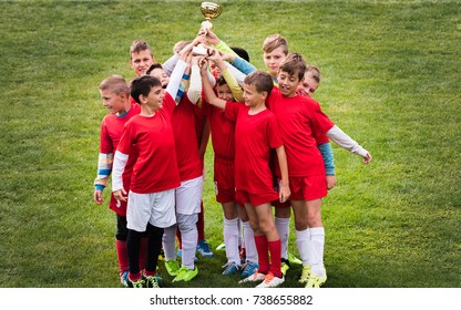 Kids Soccer Football - Young Children Players Celebrating With A Trophy After Match On Soccer Field 