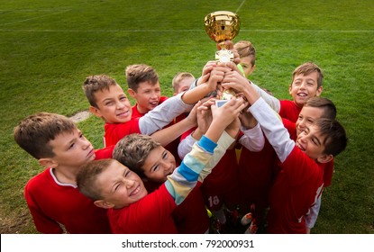 Kids Soccer Football - Young Children Players Celebrating With A Trophy After Match On Soccer Field