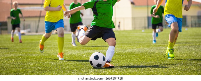 Kids in soccer teams kicking ball on sports venue. Children compete in sports school tournament. Horizontal junior level soccer background