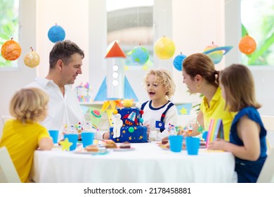 Kids space theme birthday party with cake and cupcakes. Rocket, solar system planet and astronaut decoration for child event. Little boy, friends and parents blowing candles and opening presents. - Shutterstock ID 2178458881