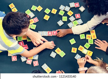 Kids Spelling Out Words With Alphabet Blocks