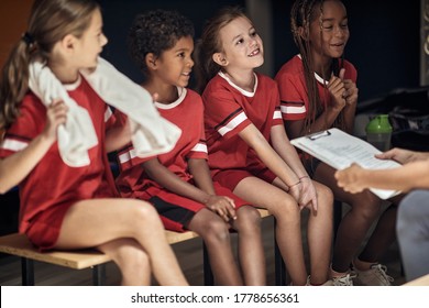 Kids Sport Team In Changing Room.Young Players Sitting On Bench.