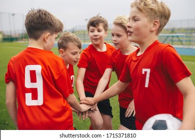 Kids Stacking Hands In Sports Team. Boys Sports Team Hands Stacked. Kids Sports Soccer Players In A Circle Gathering Before The Tournament Match