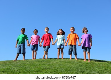 Kids standing on grass hill with blue sky