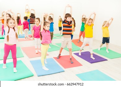 Kids Stretching During Gymnastic Lesson In Gym