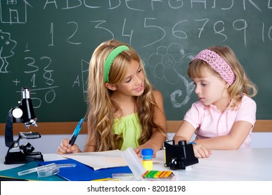 Kids Students In Classroom Helping Each Other At School Desk