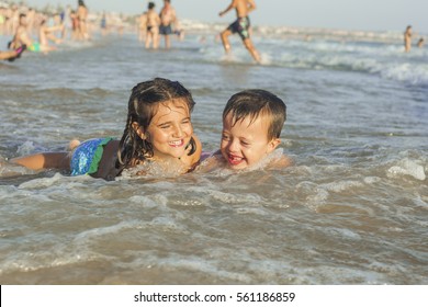 Kids Swiming And Playing In The Seashore Of The Beach