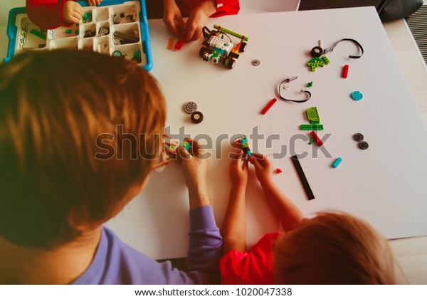 kids and teacher building robot at robotic\
technology school lesson